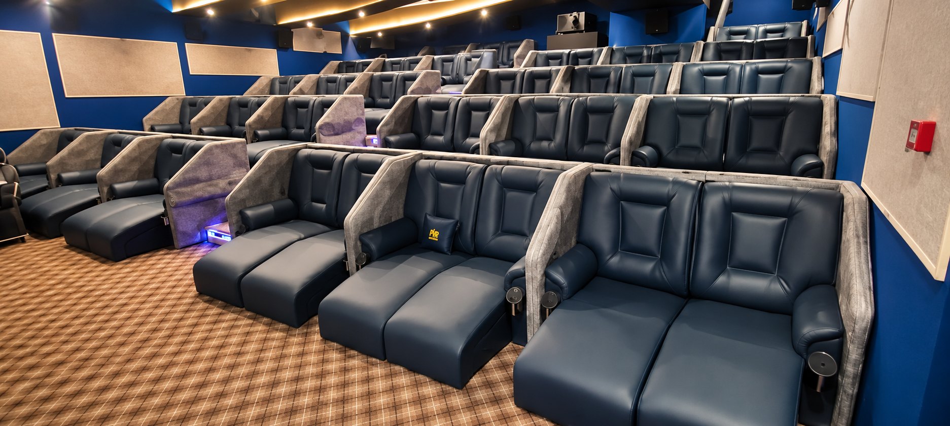 Rows of blue theatre recliner seating upholstered by Kapital